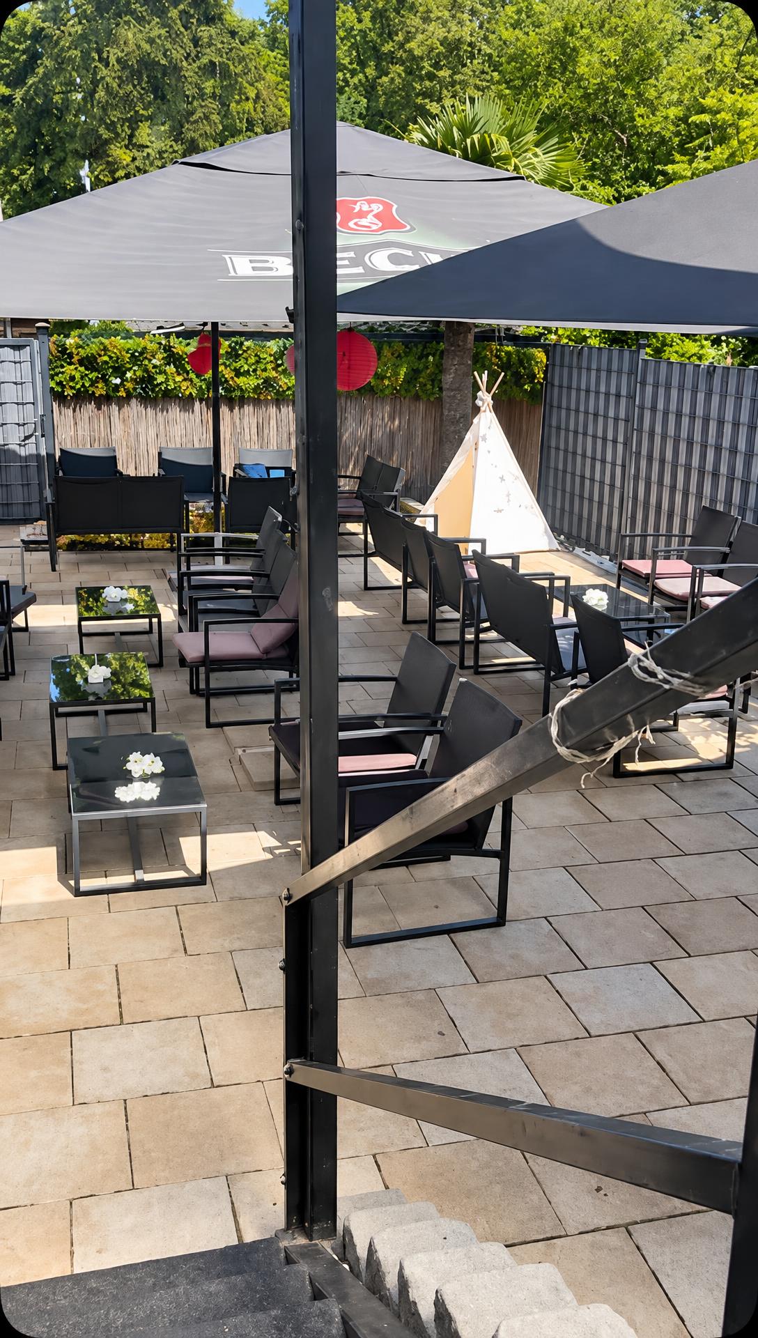 Blick auf die Terrasse mit Sonnenschirmen, Tischen und Stühlen